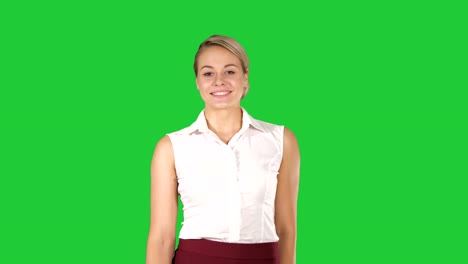 Schöne-junge-Frau-zu-Fuß-in-Richtung-Kamera-und-lächelnd-auf-einem-Green-Screen,-Chroma-Key