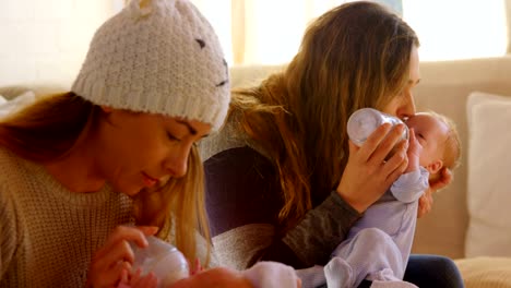 Lesbian-couple-feeding-to-their-baby-at-home-4k