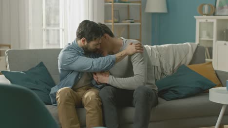 Drama-gay-triste-concepto.-Novio-es-infeliz-y-deprimido-sobre-algo.-Su-amigo-Gay-es-reconfortante,-sosteniendo-su-mano.-Miserable-el-hombre-pone-su-cabeza-en-un-hombro-y-gritos.