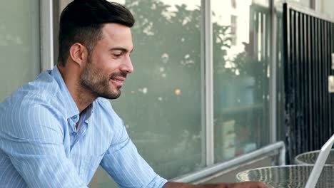 Happy-handsome-man-using-his-laptop-computer