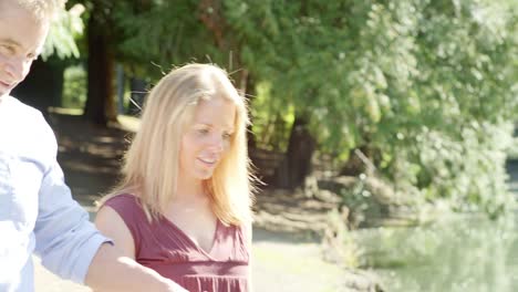 Mature-Couple-Look-Out-Over-a-Pond-in-a-Park