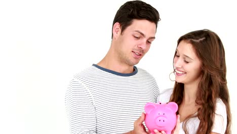 Smiling-couple-holding-piggy-bank