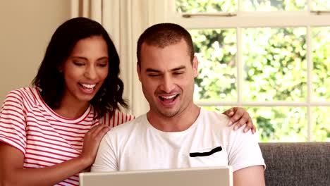 Happy-couple-using-laptop