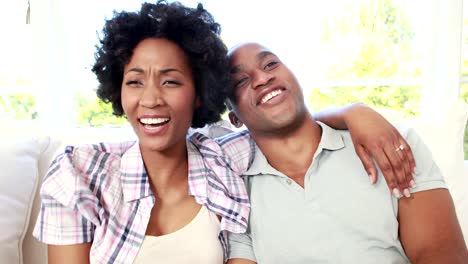 Happy-couple-watching-tv-on-the-couch