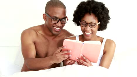 Smiling-young-couple-reading-book-together