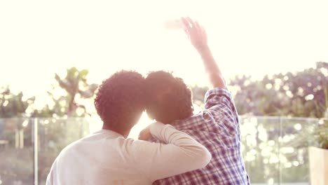 Rear-view-of-homosexual-couple-taking-selfie