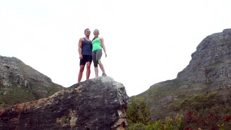 Happy-couple-standing-on-rock