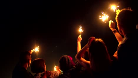 Jóvenes-amigos-celebrar-en-el-último-piso-con-luces-de-Bengala