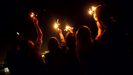 Jóvenes-amigos-celebrar-en-el-último-piso-con-luces-de-Bengala