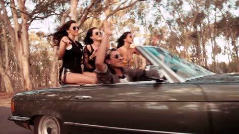 Teenager-friends-raising-arms-to-celebrate-their-summer-road-trip