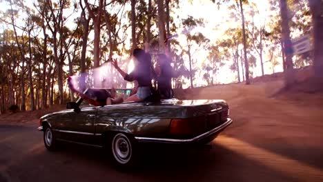 Teenager-friends-embracing-joyfully-on-their-road-trip-at-sunset