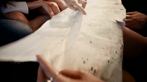 Group-of-young-hipster-friends-looking-at-map-in-vintage-van