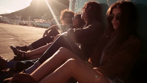 Hipster-friends-resting-out-of-their-van-at-sunset