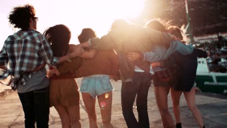 Teen-hipster-friends-walking-on-the-pier-at-sunset