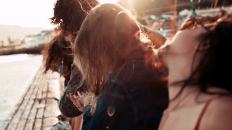 Adolescente-ESTILO-hipster-amigos-bailando-en-el-Muelle-al-anochecer