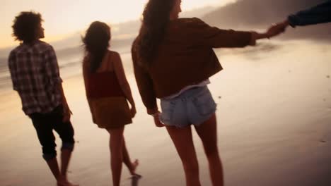 Teen-friends-enjoying-a-walk-at-beach-on-sunset