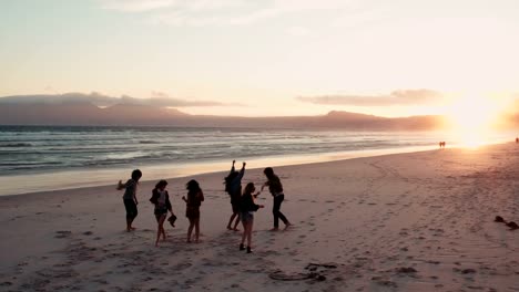 Silueta-de-Teen-amigos-bailando-en-la-playa-al-anochecer