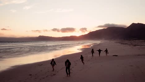 Teen-Freunde-genießen-einen-Spaziergang-am-Strand-bei-Sonnenuntergang