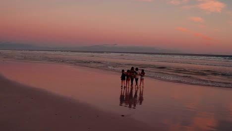Teen-Freunde-genießen-einen-Spaziergang-am-Strand-bei-Sonnenuntergang
