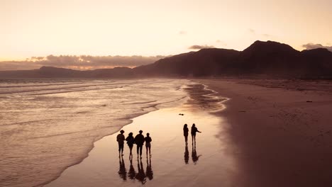 Teen-Freunde-genießen-einen-Spaziergang-am-Strand-bei-Sonnenuntergang