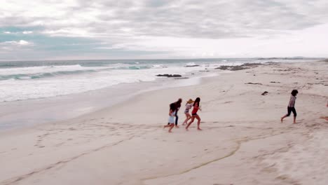 Hipster-friends-doing-funny-piggyback-rides-on-beach