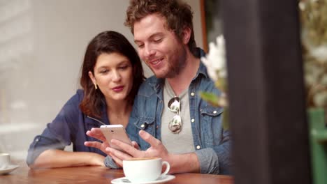 Woman-and-Man-sitting-in-coffee-shop-with-Phone