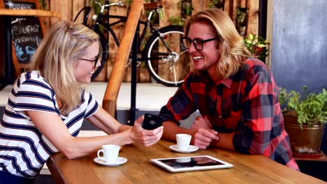 Girlfriend-showing-smartphone-to-boyfriend