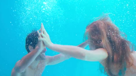 Happy-couple-swimming-underwater