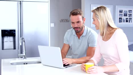 Couple-using-laptop-in-the-kitchen