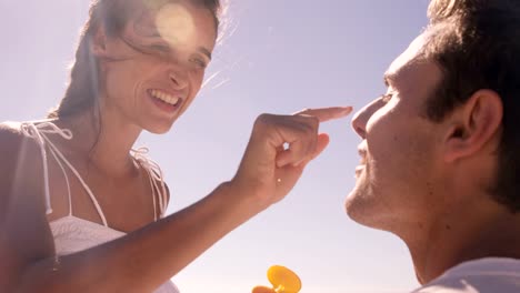 Mujer-poniendo-protector-solar-a-su-novio