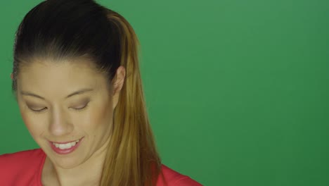 Beautiful-young-lady-raising-her-eyebrows-and-being-flirty,-on-a-green-screen-studio-background