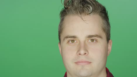 Young-man-staring-ahead,-on-a-green-screen-studio-background