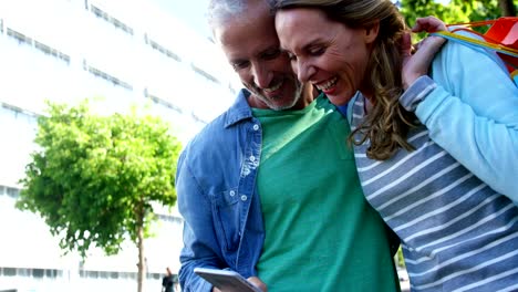 Pareja-está-sonriendo-y-mirando-un-smartphone