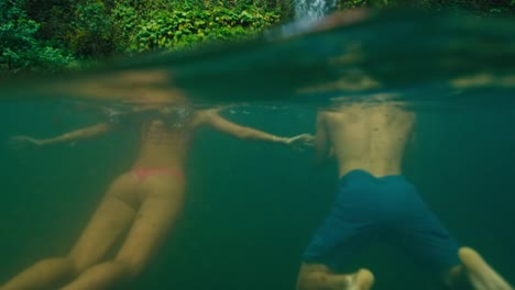 Couple-Swimming-to-Waterfall