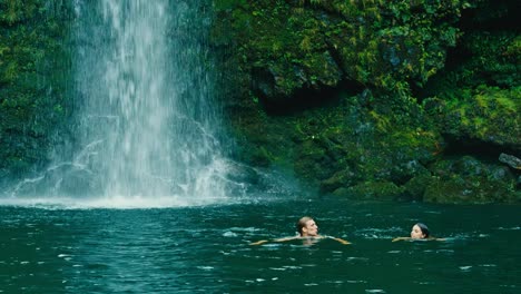 Paar-schwimmen-zum-Wasserfall