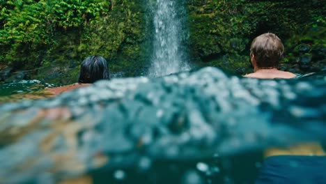 Couple-Swimming-to-Waterfall