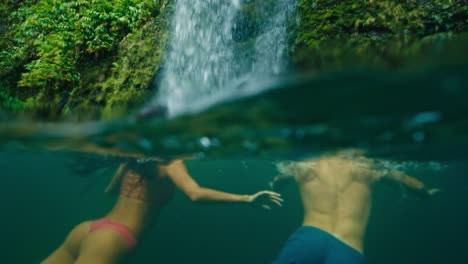 Paar-schwimmen-zum-Wasserfall