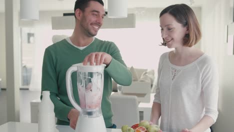 Feliz-pareja-romántica-está-haciendo-batidos-en-la-licuadora-en-la-cocina-en-casa.