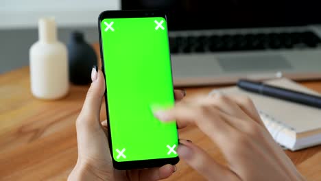 Person-using-cellphone-with-greenscreen-display-in-hand