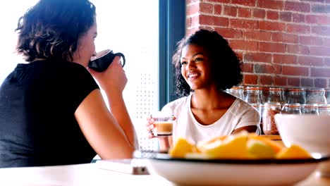 Pareja-de-lesbianas-interactuando-con-otros-desayunando