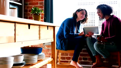 Pareja-de-lesbianas-interactuando-con-los-demás-en-la-cocina