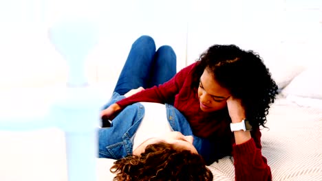 Lesbian-couple-interacting-with-each-other-on-bed