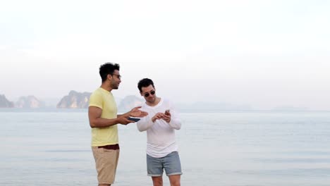 Zwei-Mann-am-Strand-mit-Zelle-Smartphones-sprechen-Gay-paar-Online-Vernetzung