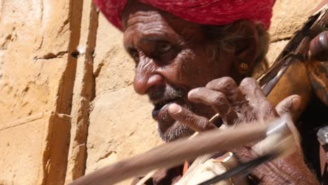 Indische-Senior-spielt-traditionelle-Musikinstrument-in-Jaisalmer-Fort,-Rajasthan,-Indien
