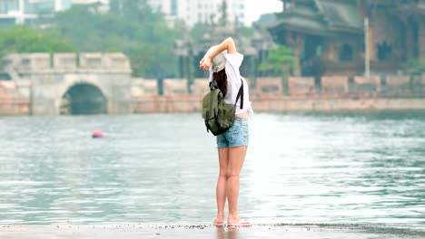 Young-woman-touirist-posing-in-front-of-the-ancient-temple.-Back-view-concept