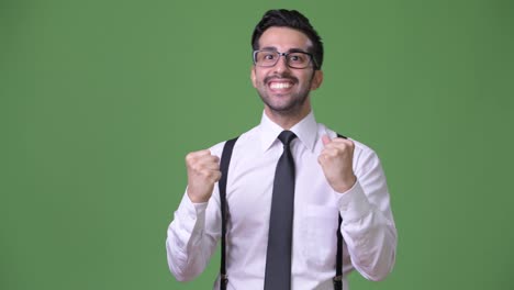 Young-handsome-bearded-Persian-businessman-against-green-background