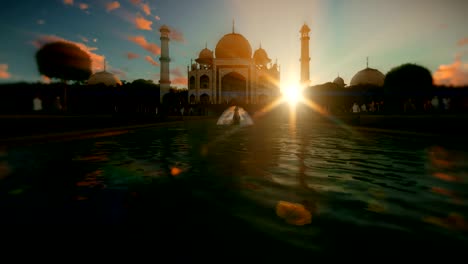 Taj-Mahal-con-turistas-caminando-contra-la-hermosa-puesta-de-sol,-zoom-en-4K