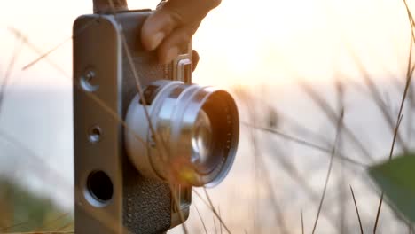 Vintage-Kamera-in-der-Hand-und-stehen-in-den-Rasen-auf-einem-Berggipfel