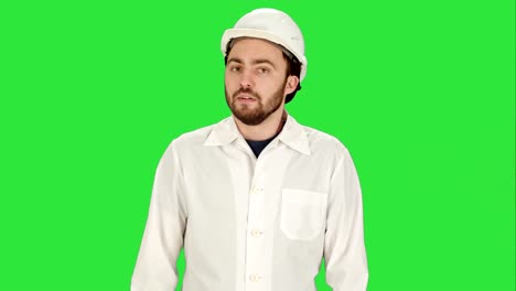 Man-in-the-construction-helmet-with-a-raised-finger-on-a-Green-Screen,-Chroma-Key