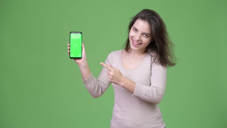 Joven-hermosa-mujer-mostrando-teléfono-y-señalar-con-dedo